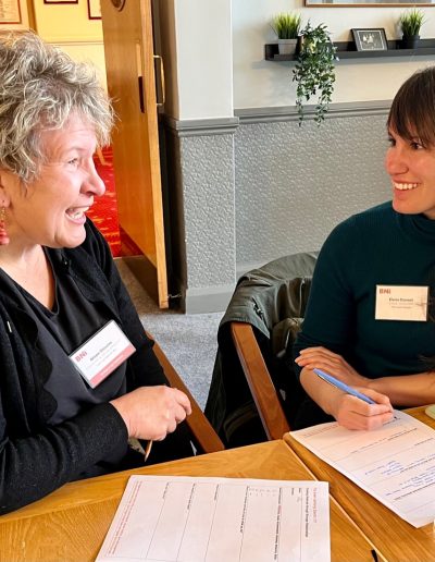 Two entrepreneurs smiling and networking at a BNI gathering.