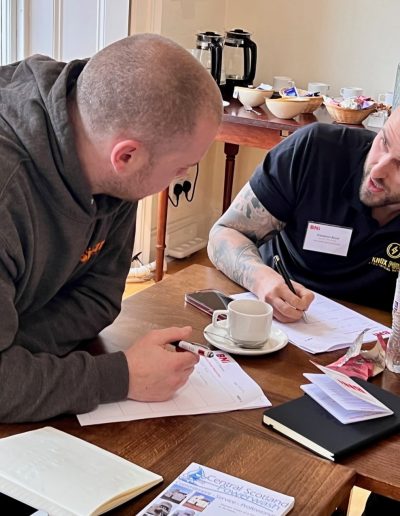 Informal business discussion between two professionals at a BNI event.