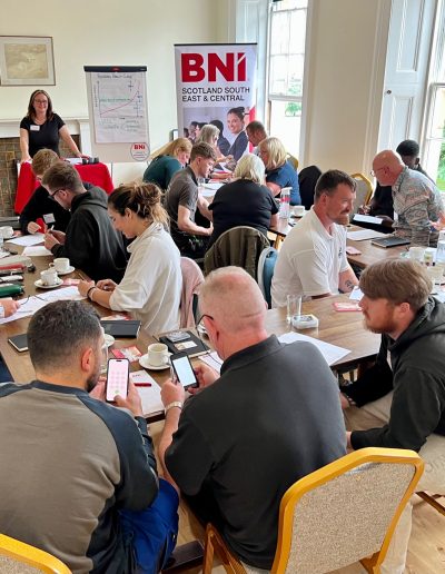 Small business team engaged in a lively discussion at a BNI gathering.